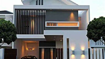 Modern two-story white house with a car parked in a covered garage area on the left and a sleek, contemporary facade with wooden slats and warm exterior lighting.