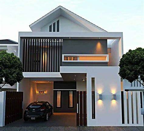 Modern two-story white house with a car parked in a covered garage area on the left and a sleek, contemporary facade with wooden slats and warm exterior lighting.
