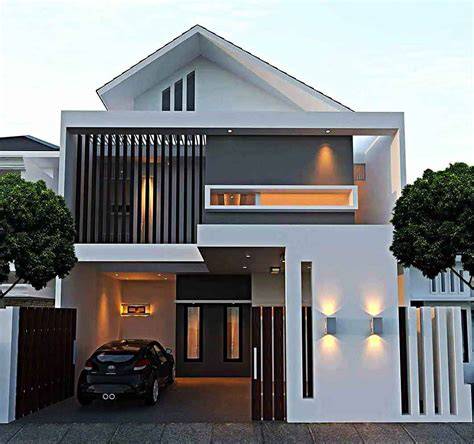 Modern two-story white house with a car parked in a covered garage area on the left and a sleek, contemporary facade with wooden slats and warm exterior lighting.